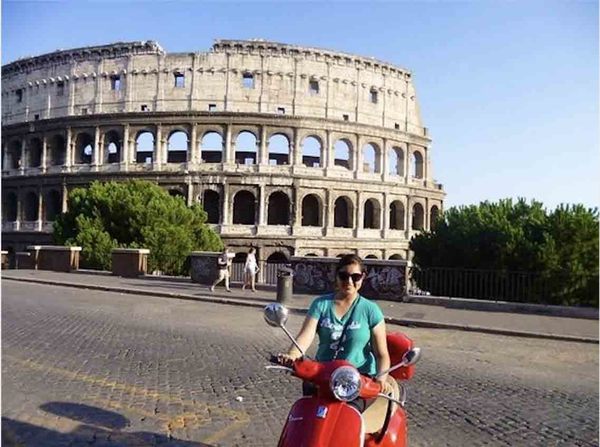 Student on scooter in front of the Colosseum in Rome